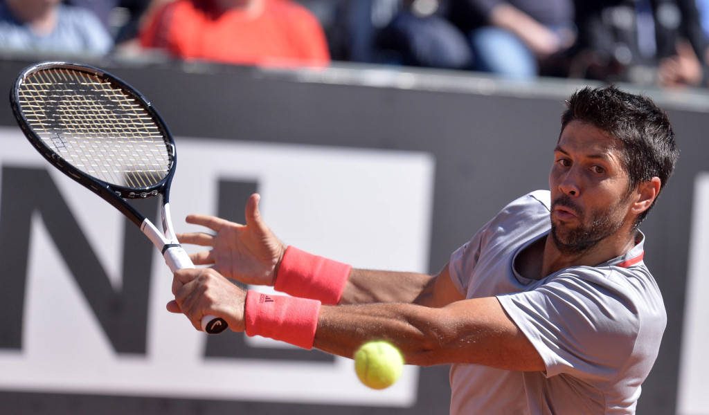 Fernando Verdasco tennis action intense swing grey shirt red wristbands yellow ball blurred court Wallpaper
