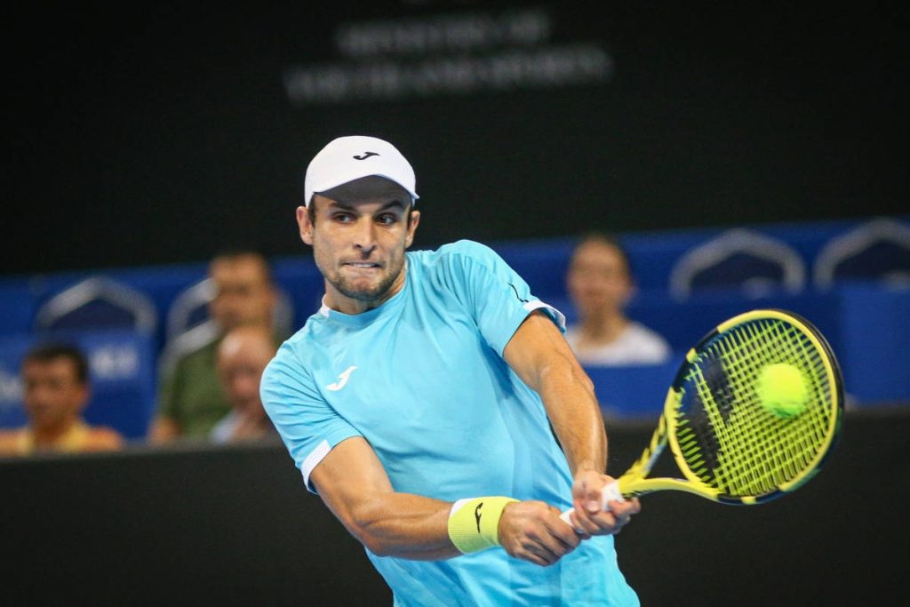 Fernando Verdasco hitting powerful two-handed backhand in light blue jersey tennis action shot Wallpaper