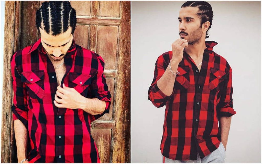 Pakistani actor Feroze Khan stylish in red black plaid shirt with braided hair against rustic wood background Wallpaper