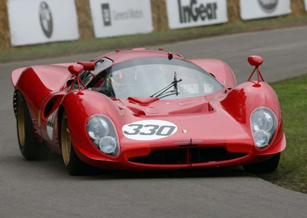 Classic red Ferrari 330 P vintage sports car on scenic racing track wallpaper background
