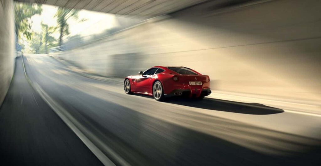 Unleashing Elegance and Power: Ferrari F12 Berlinetta Dominating the Serene Countryside Wallpaper