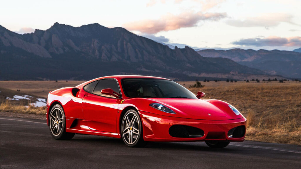 Red Ferrari F430 parked on mountain road showcasing luxury sports car elegance and performance Wallpaper
