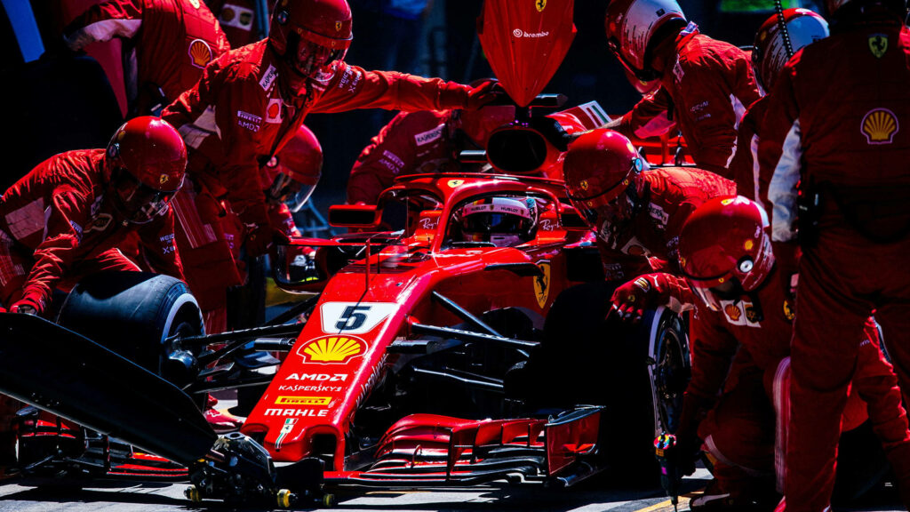 Ferrari Formula 1 race car pit stop with pit crew teamwork and precision in action wallpaper