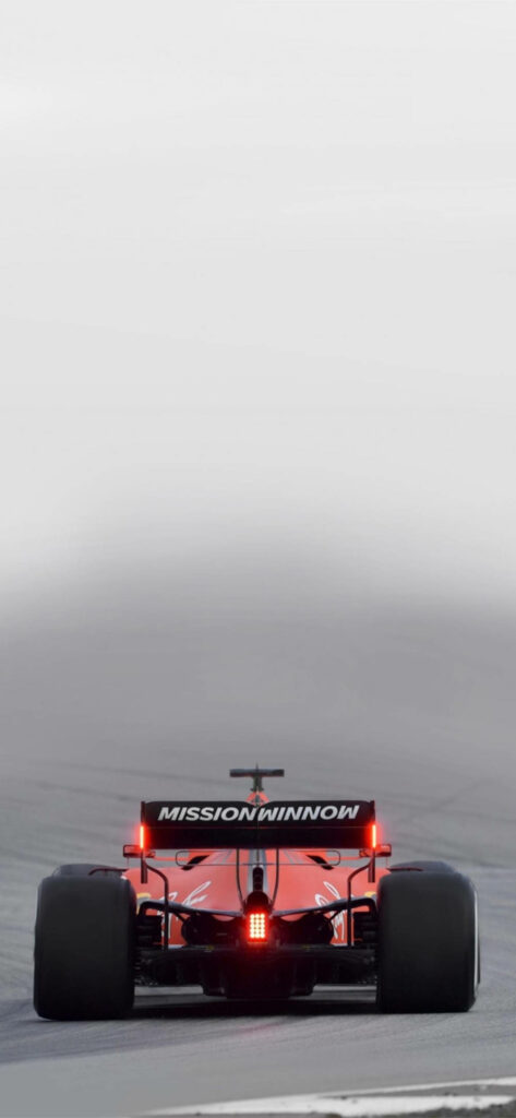 Speed Demon: Ferrari F1 Roaring through Enigmatic Mist on Race Track Wallpaper
