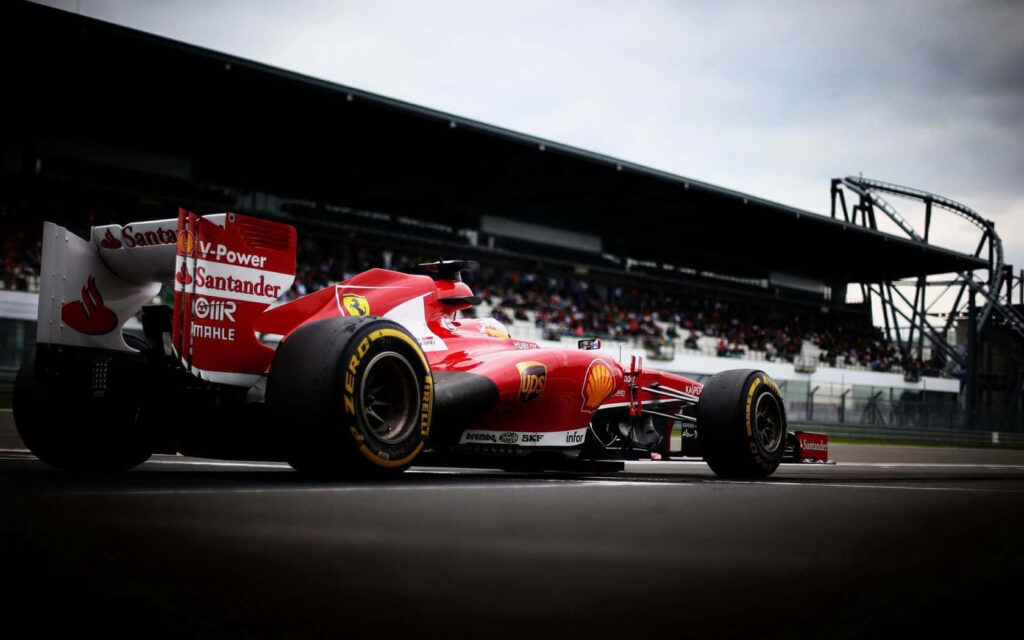 Revving Ahead: Thrilling Ferrari F1 Speeds towards Victory in Majestic Racing Ambiance Wallpaper