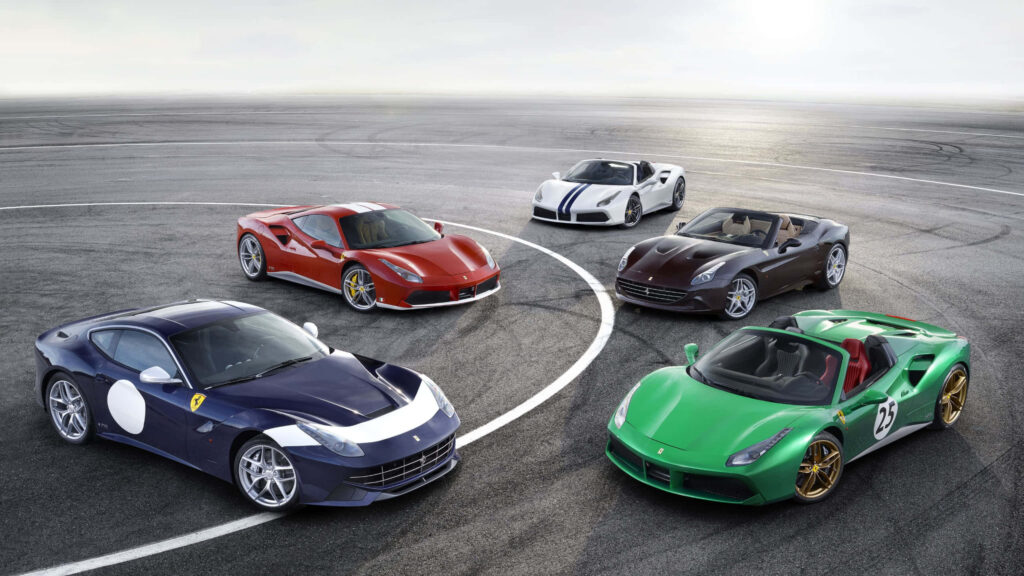 Luxury Ferrari racing cars lineup on track showcasing vibrant colors and sleek aerodynamic design Wallpaper