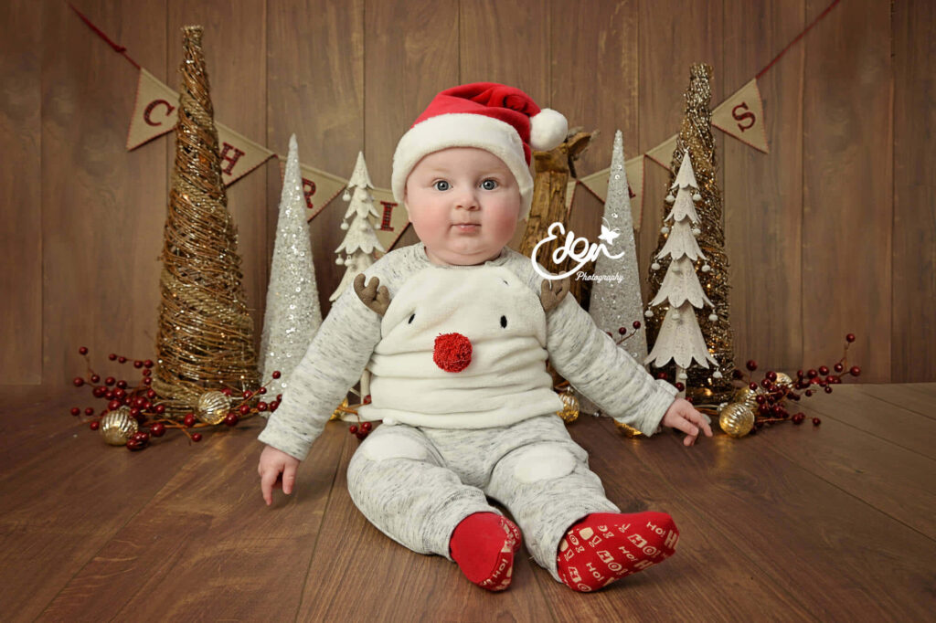 Festive Baby in Santa Hat - Charming Christmas Wallpaper
