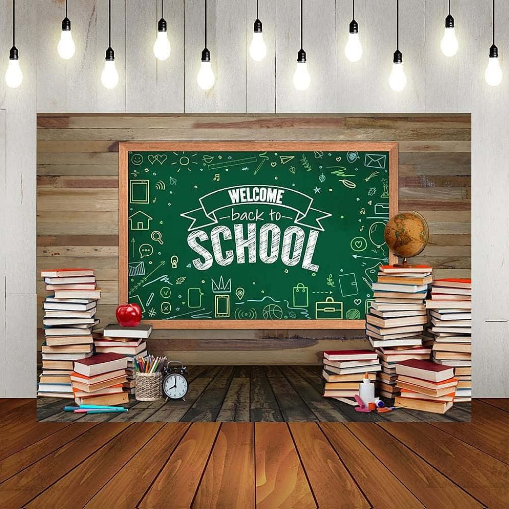 Festive back to school backdrop with chalkboard books apple globe clock and warm string lights Wallpaper