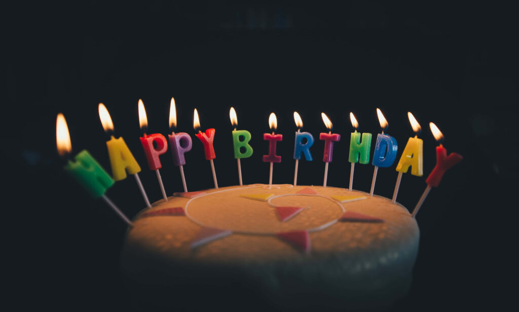 Festive Birthday Cake Wallpaper with Colorful Candles - Cheerful Decor