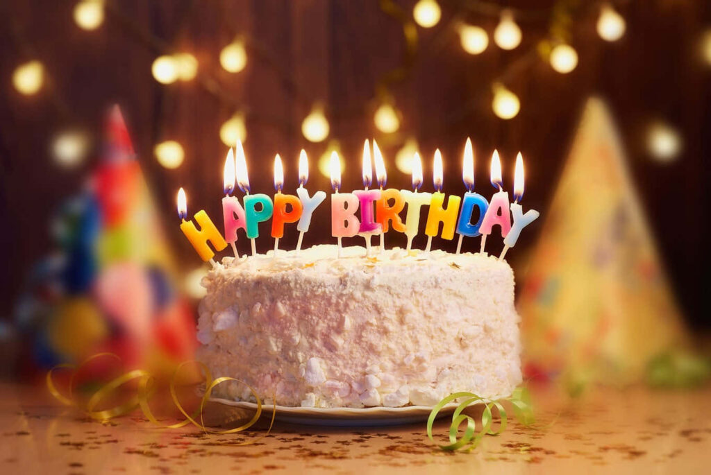 Festive Birthday Cake with Candles & Colorful Party Atmosphere Wallpaper