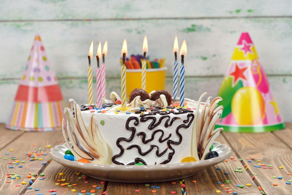 Festive Birthday Cake Wallpaper with Colorful Candles & Confetti