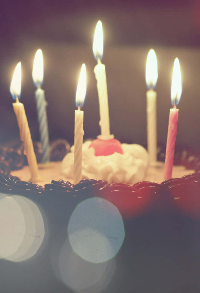 Festive Birthday Cake with Flickering Candles - Warm iPhone Wallpaper