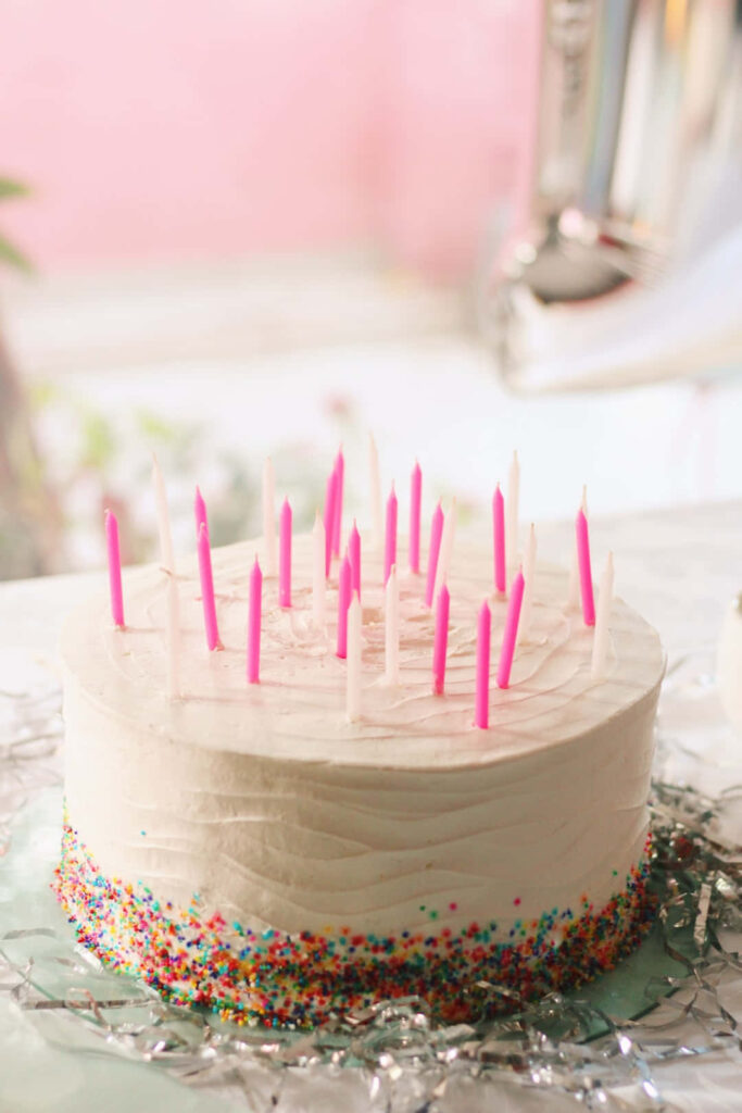 Festive Birthday Cake Wallpaper with Pink Candles and Sprinkles