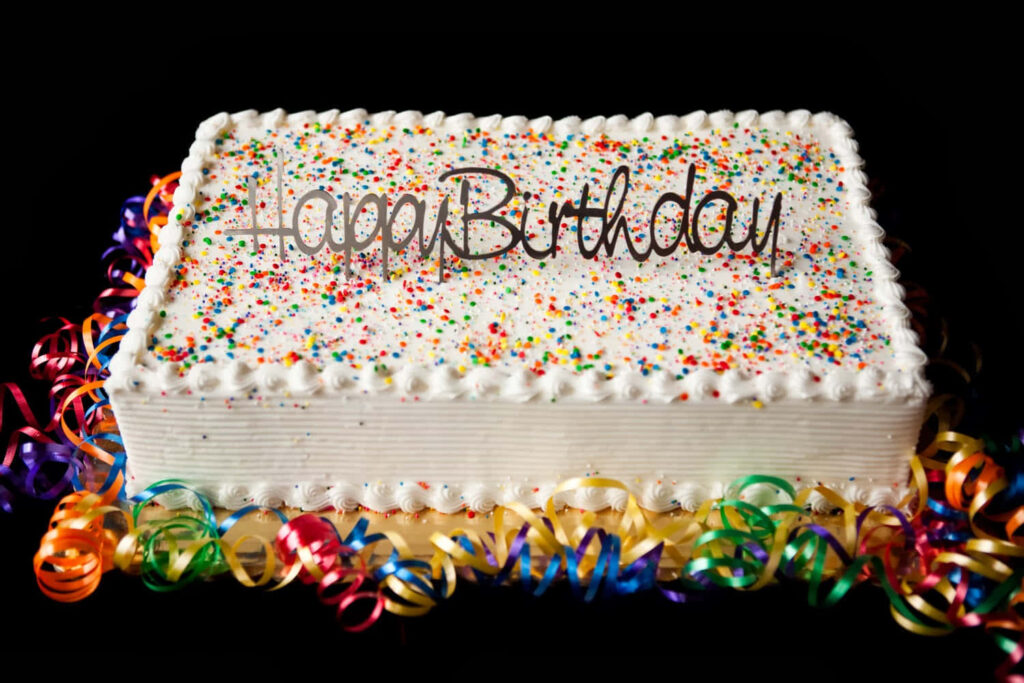 Festive Birthday Cake with Colorful Sprinkles & Ribbons Background Wallpaper