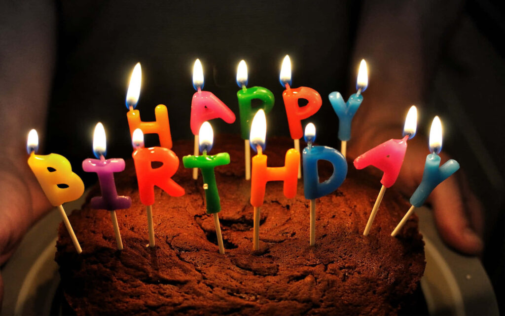 Festive Birthday Scene: Chocolate Cake with Lit HAPPY BIRTHDAY Candles Wallpaper