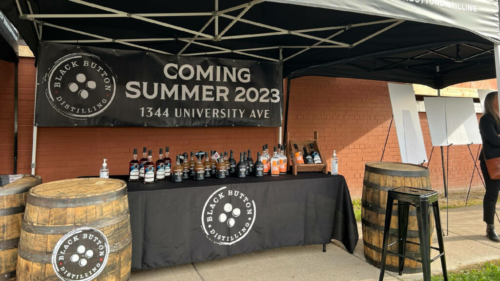 Black Button Distilling spirits display under banner at festive outdoor beer weekend celebration background Wallpaper