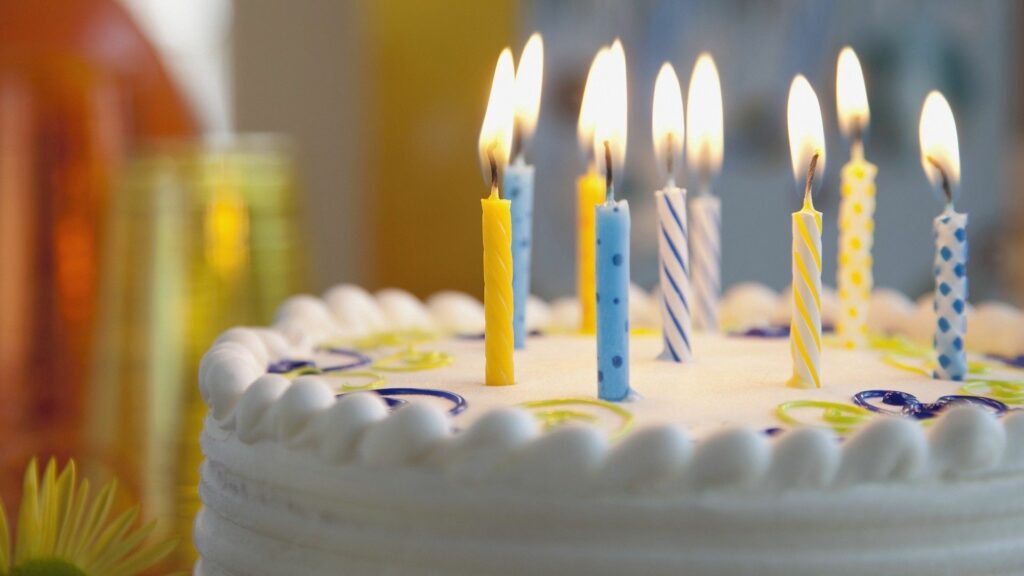 Colorful Candle-Topped Cake: Celebratory Wallpaper Background