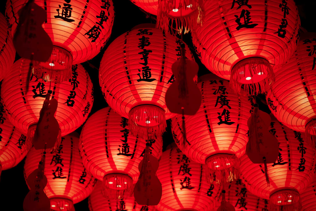 Vibrant red Chinese paper lanterns glowing warmly creating festive traditional wallpaper background