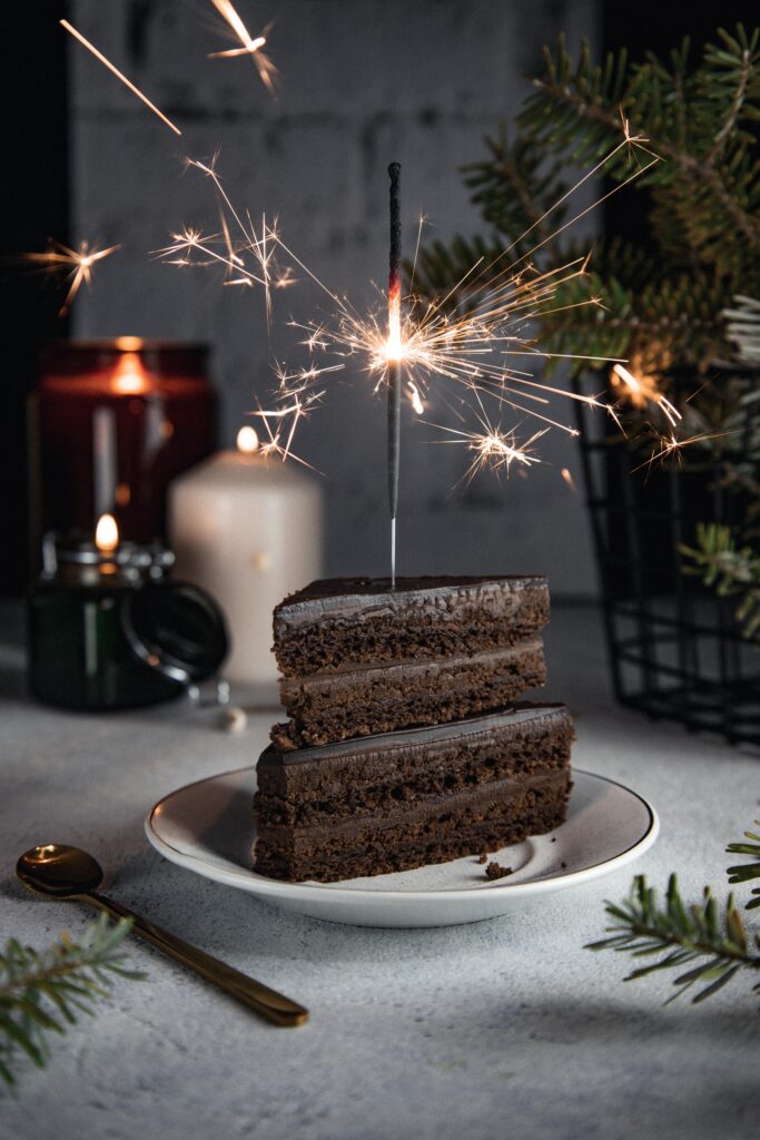 Festive Chocolate Cake Slice with Sparkler: Cozy Wallpaper Background