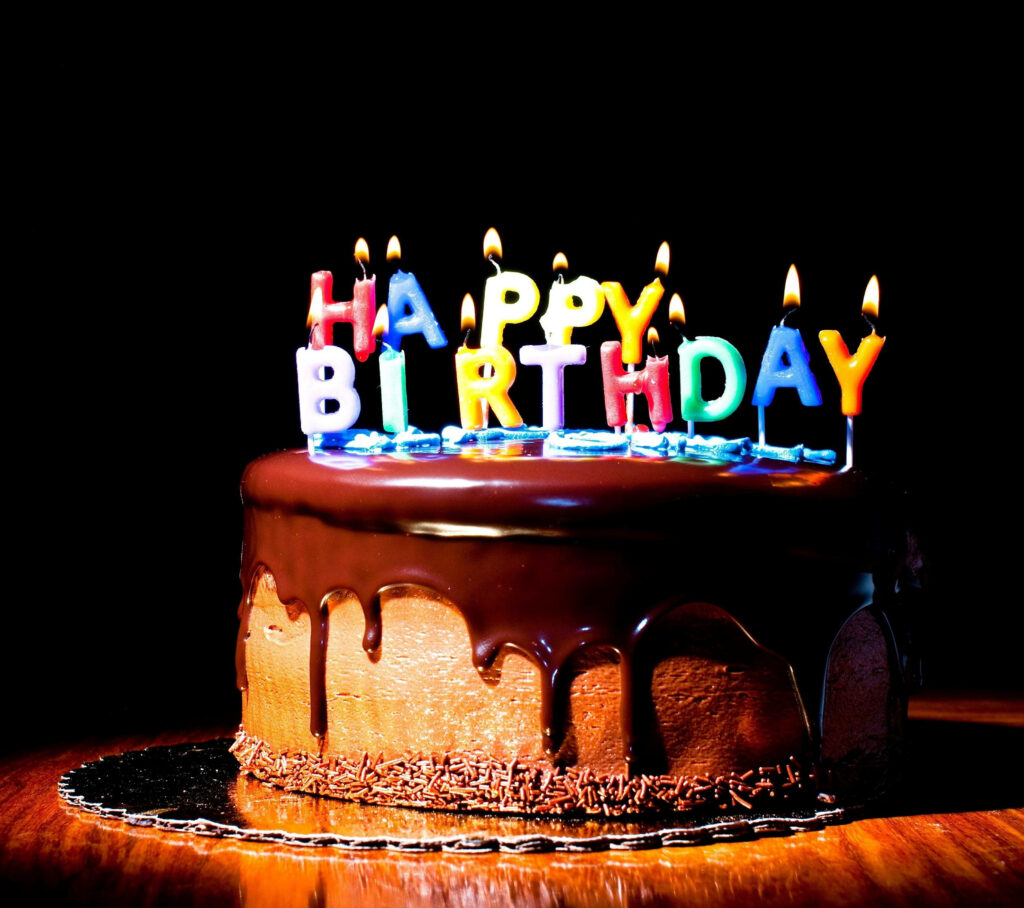 Festive Chocolate Cake with Colorful Happy Birthday Candles Wallpaper