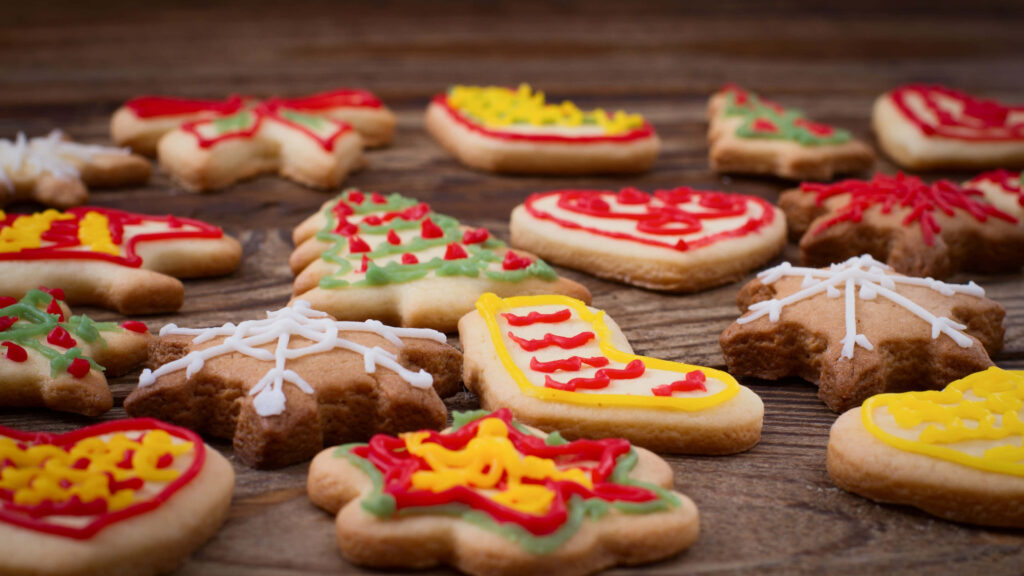 Festive Holiday Cookies on Wooden Surface | Vibrant Christmas Treats Wallpaper