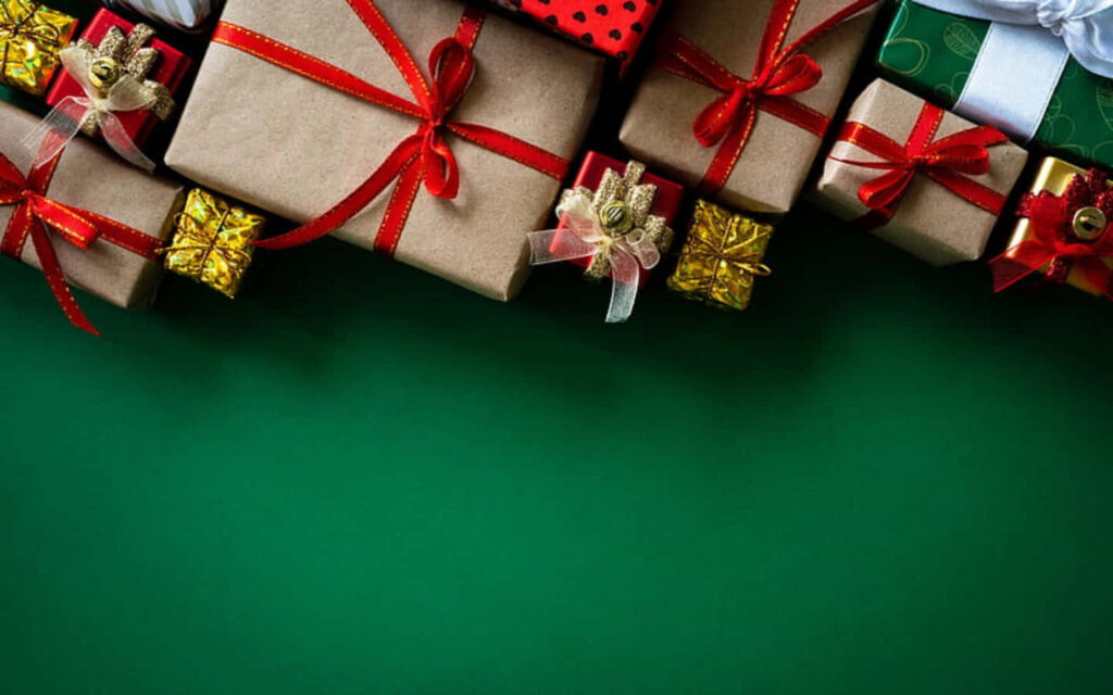Festive Christmas Gifts with Red Ribbons on Green Background Wallpaper