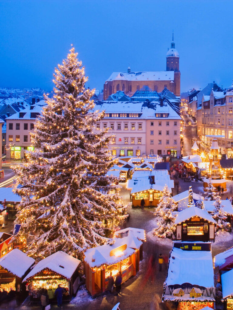 Charming Snowy Christmas Market Scene in Festive Town Square Wallpaper