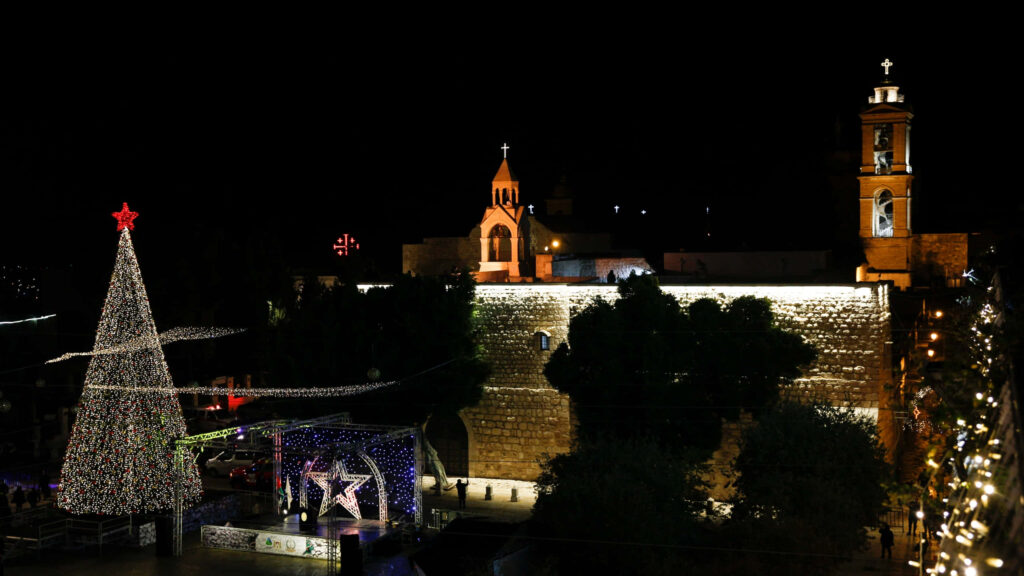 Festive Christmas Night Wallpaper: Lit Tree & Historic Buildings