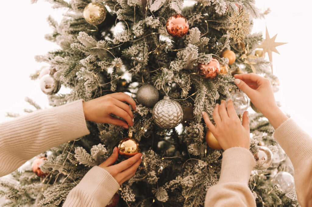 Cozy Christmas Tree Decorating with Shimmering Ornaments Wallpaper