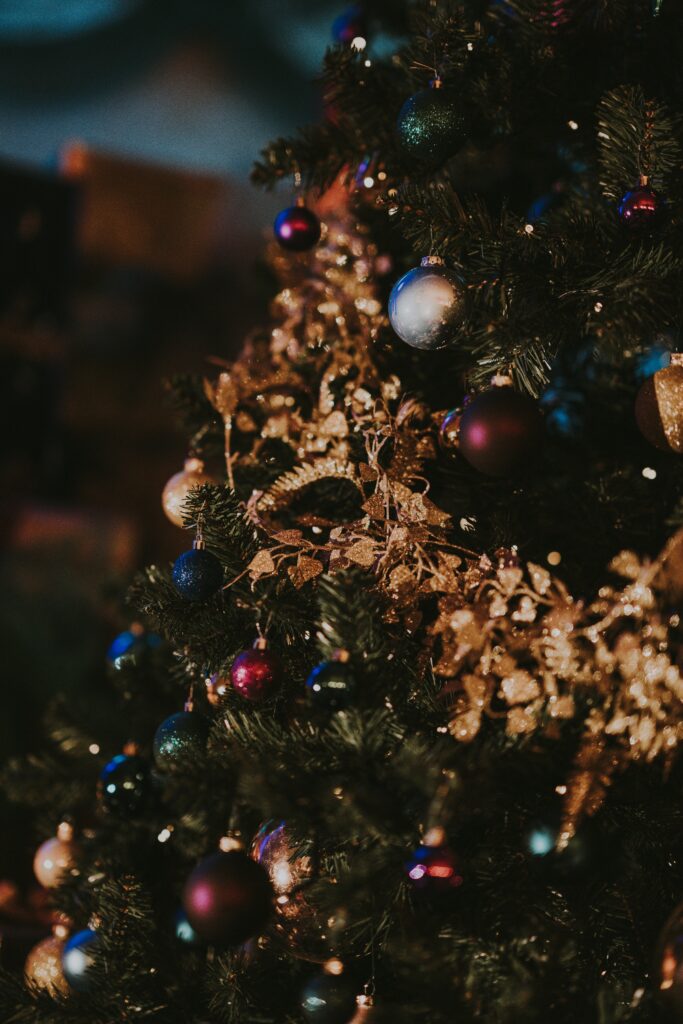 Festive Christmas Tree with Gold, Blue & Purple Ornaments in Bright Glow Wallpaper