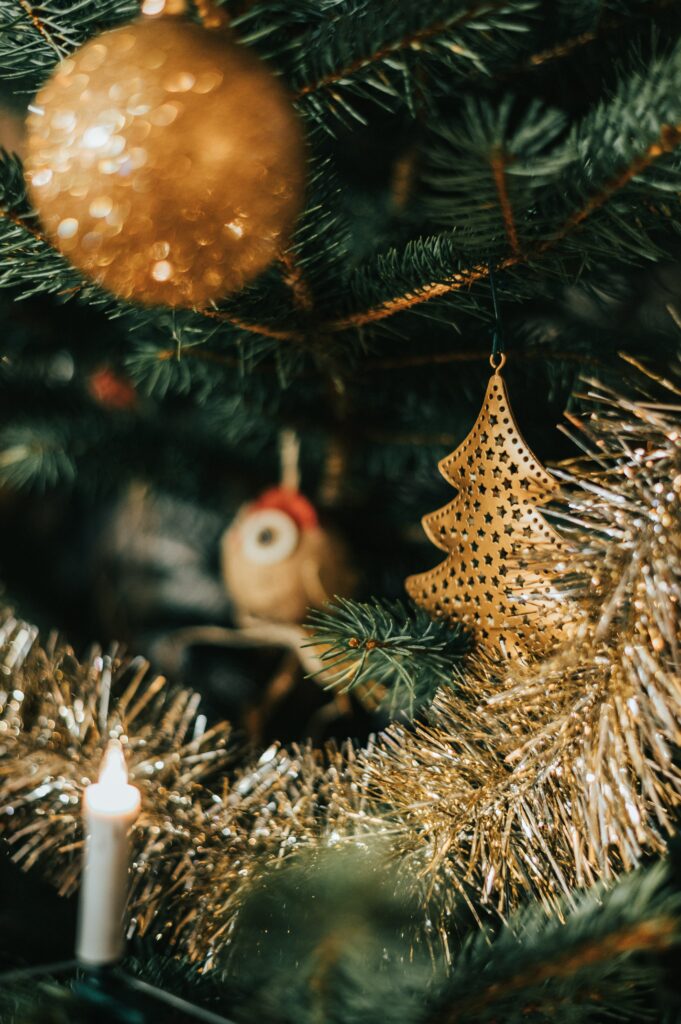 Festive Christmas Tree with Tinsel & Golden Decor for Holiday Cheer Wallpaper