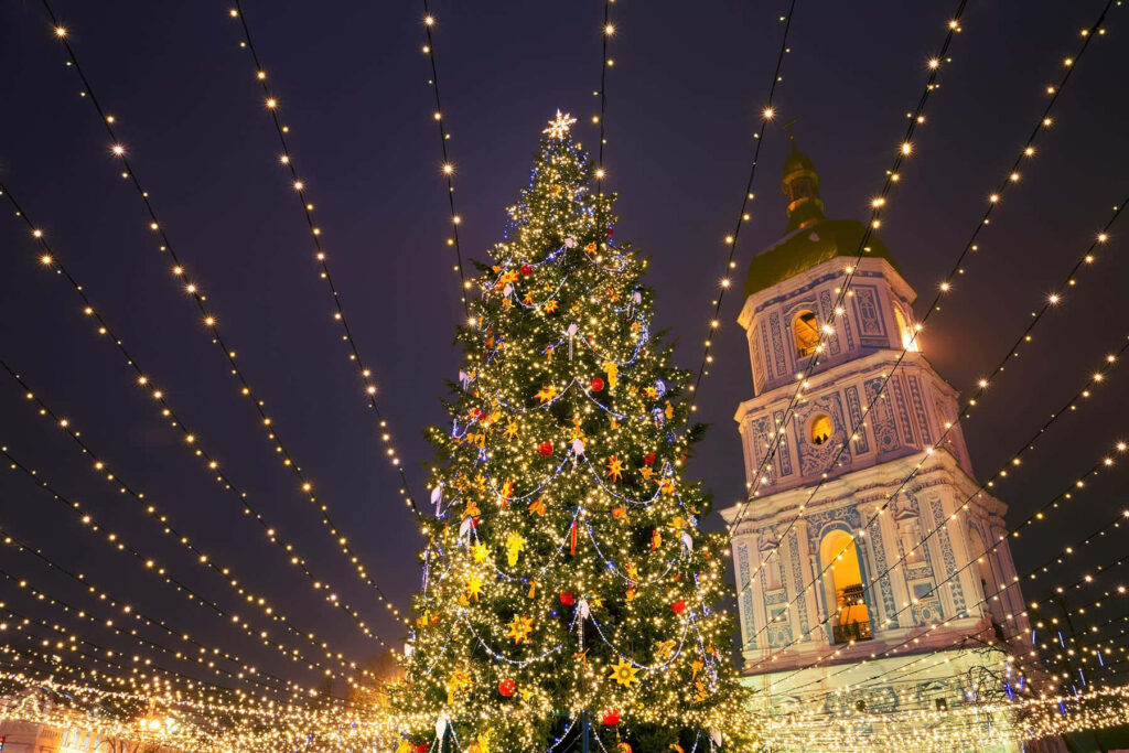 Festive Christmas Tree Wallpaper with Sparkling Lights at Night