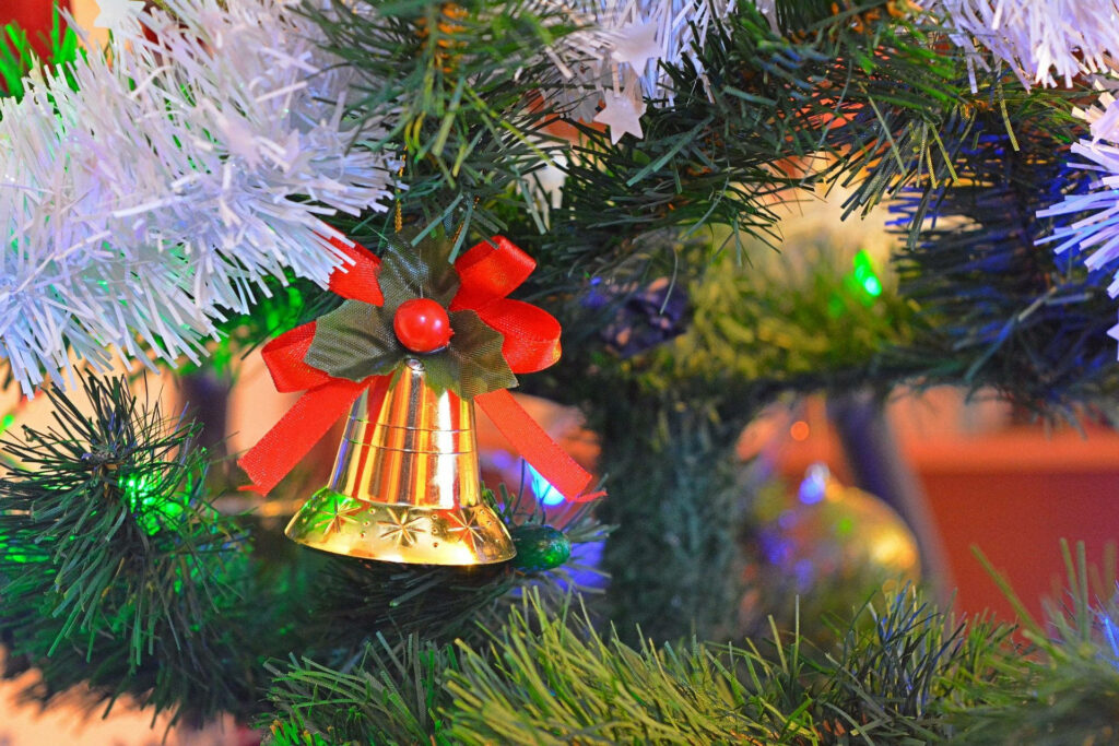 Vibrant Christmas Tree Wallpaper with Gold Bell & Colorful Lights