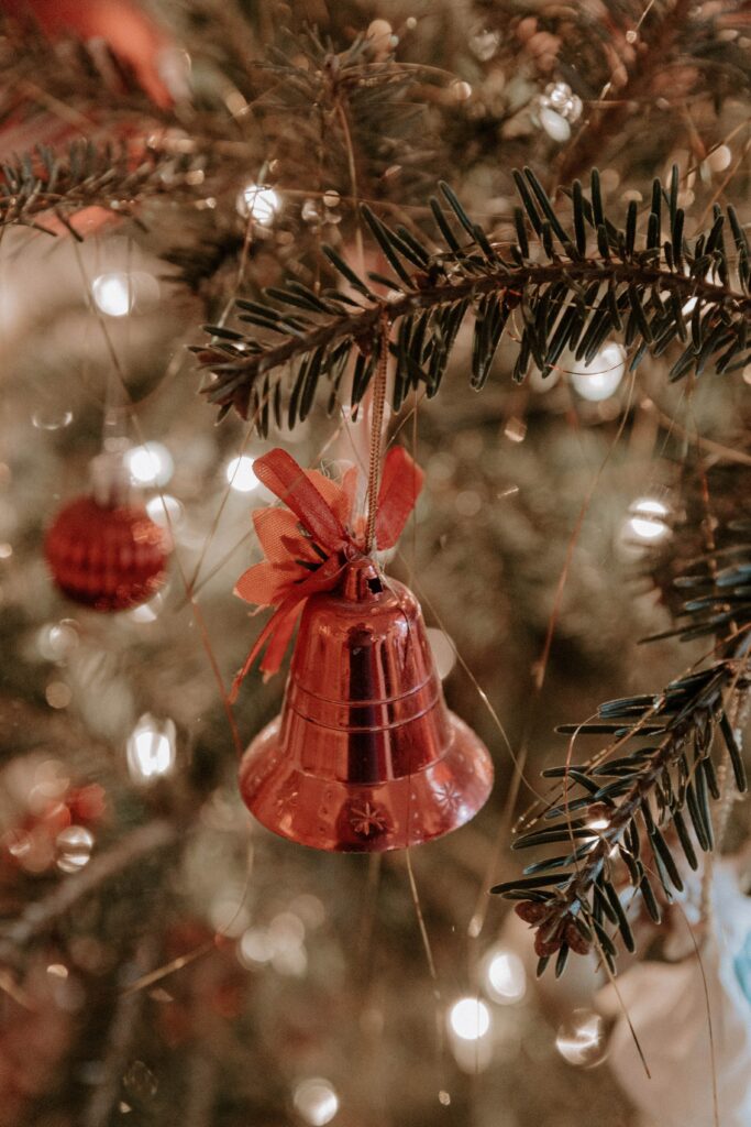 Cozy Christmas Tree Wallpaper with Bell Ornament & Warm Lights