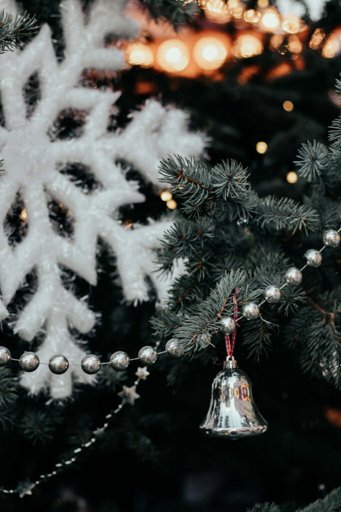 Close-Up Christmas Tree Wallpaper with Silver Bell & Snowflakes