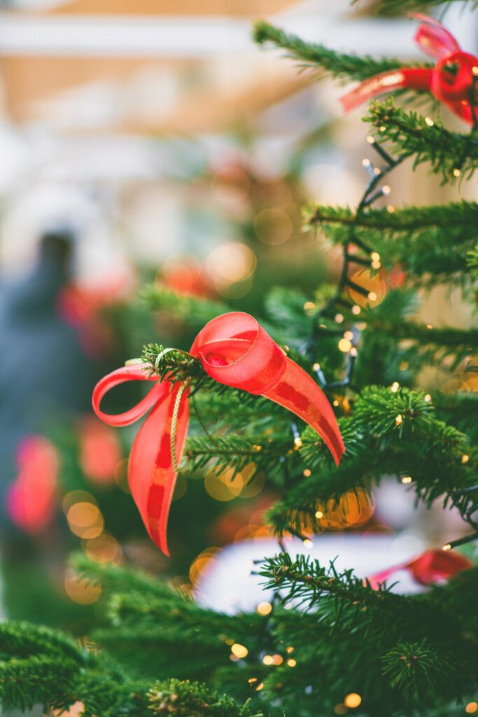 Elegant Christmas Tree Wallpaper: Twinkling Lights & Red Bows