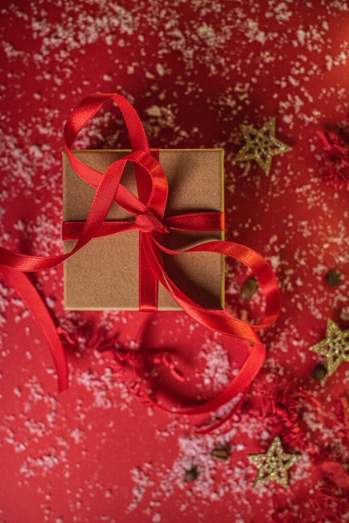 Festive Christmas Wallpaper: Gift Box with Red Ribbon & Gold Stars