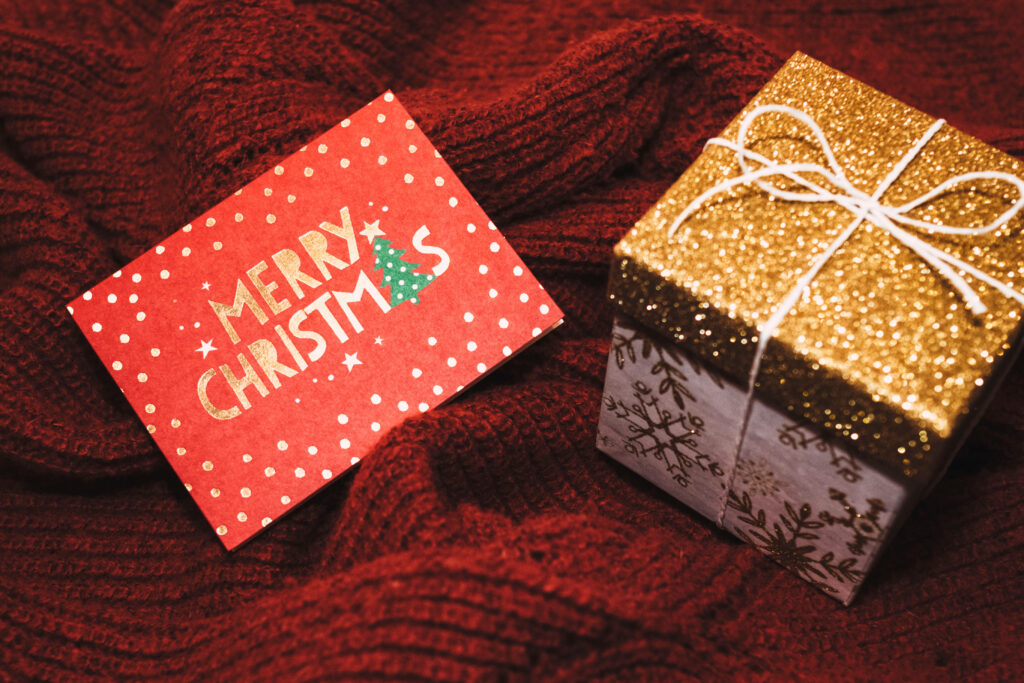 Cozy Christmas Wallpaper: Gold Gift Box & Merry Card on Red Fabric