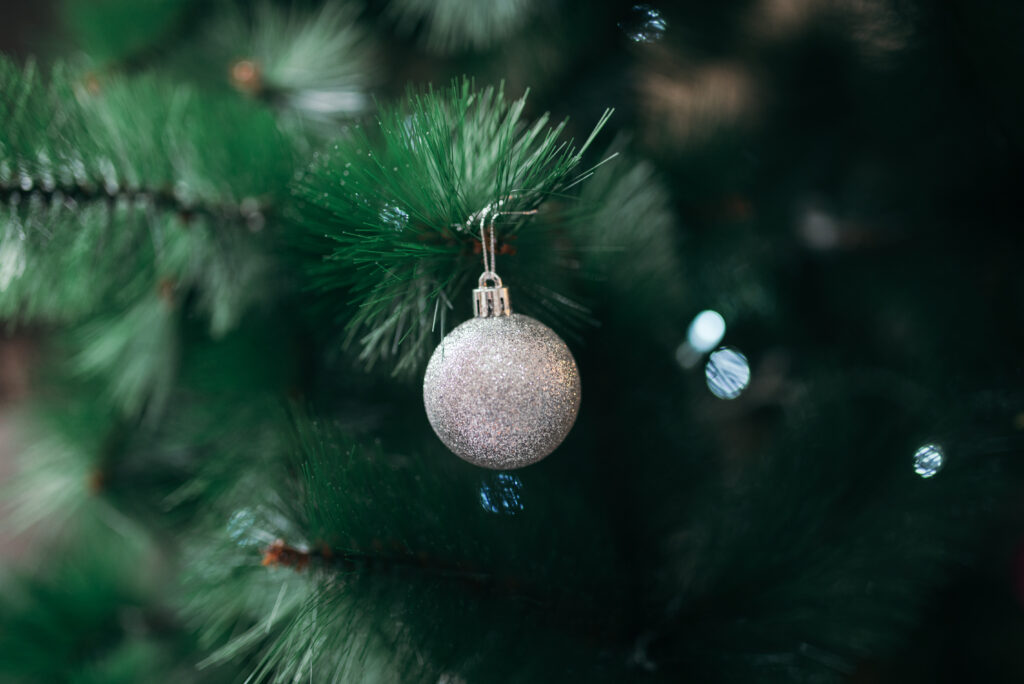 Festive Christmas Wallpaper: Sparkling Silver Ornament on Green Branch
