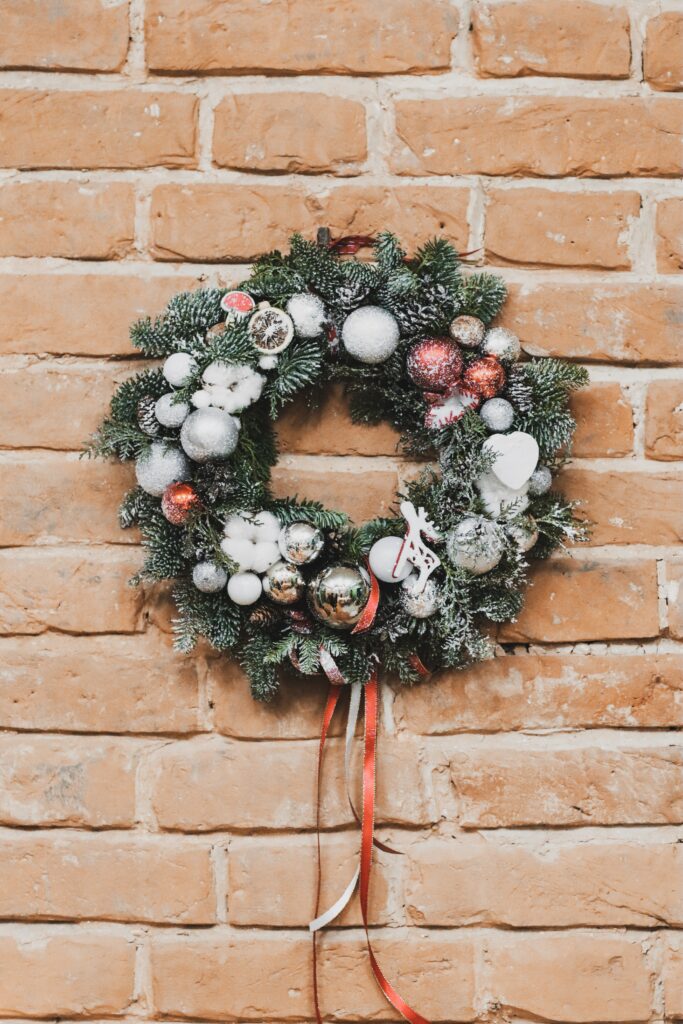 Festive Christmas Wreath Wallpaper: Holiday Cheer on Rustic Brick