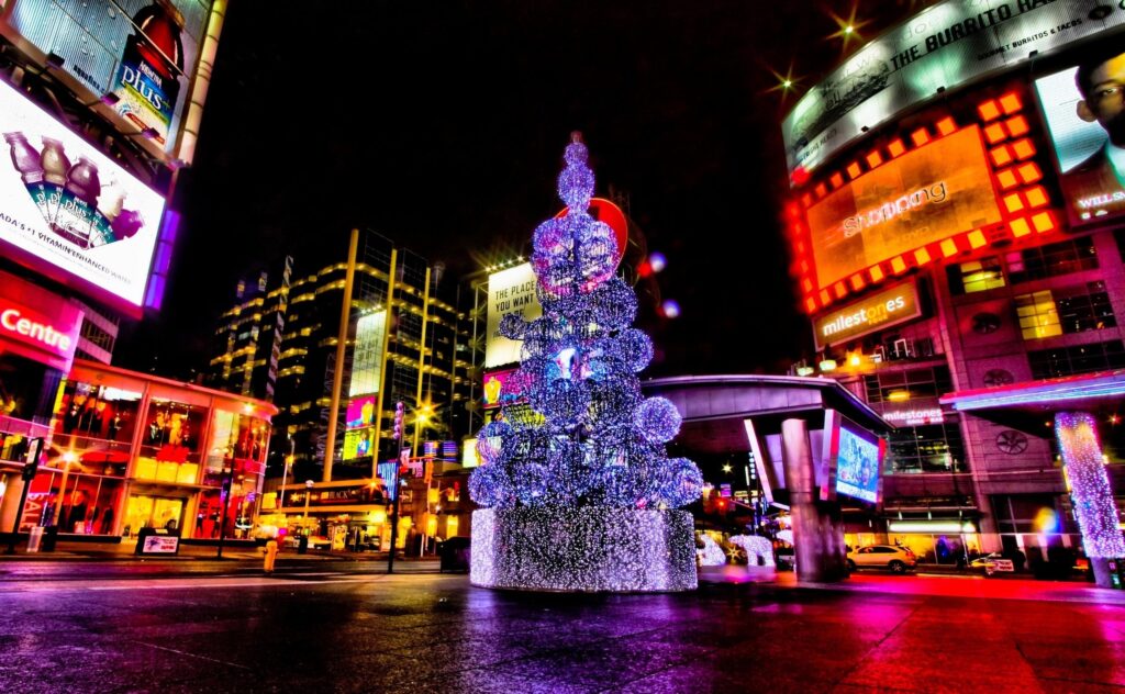 Festive City Street Wallpaper: Illuminated Christmas Tree Scene