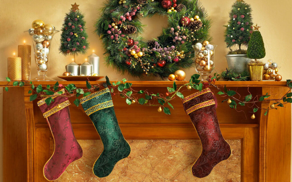 Festive Delight: Charming Christmas Stockings Adorned with Wreath, Miniature Trees, Candles, and Elegantly Hanging Decorations Wallpaper