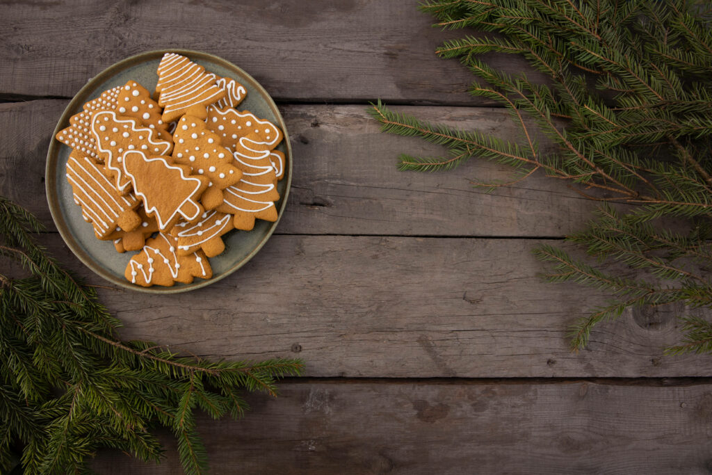 Festively adorned tree-shaped Christmas cookies on a chic grey tray, adorned with delicate leaf decorations Wallpaper