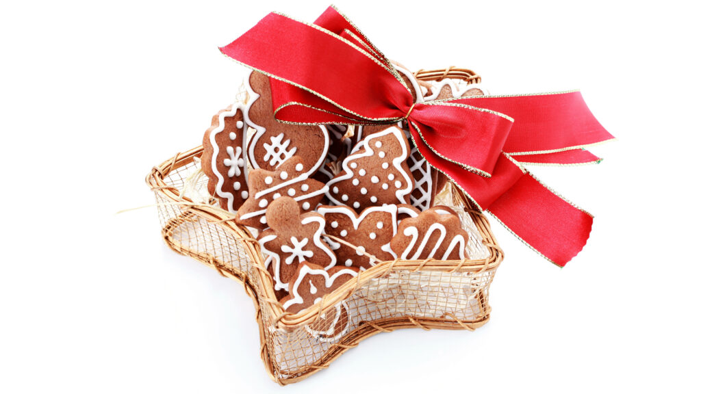 Festive Delights: Artfully Arranged Gingerbread Cookies on Antique Wooden Basket, Adorned with a Striking Red Ribbon Wallpaper
