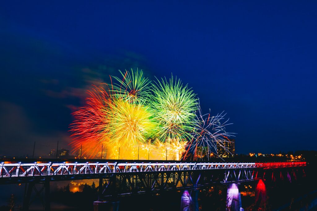 Colorful Fireworks Wallpaper: Festive Night Sky Over a Beautiful Bridge