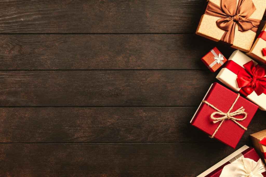 Festive Wrapped Gifts on Rustic Wood: Perfect Holiday Background Wallpaper