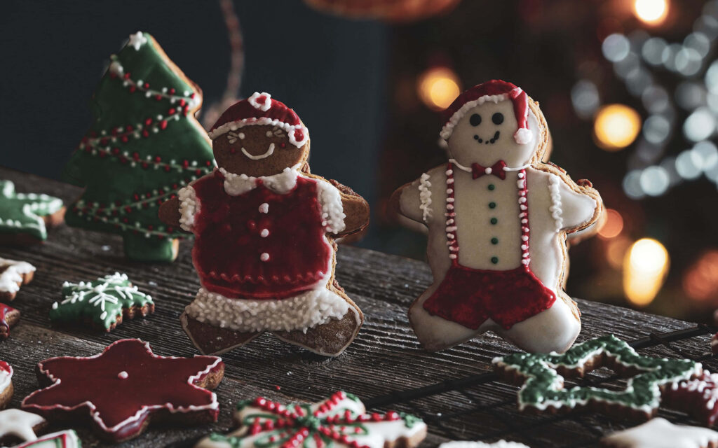Charming Festive Gingerbread Cookies on Rustic Wooden Surface Wallpaper