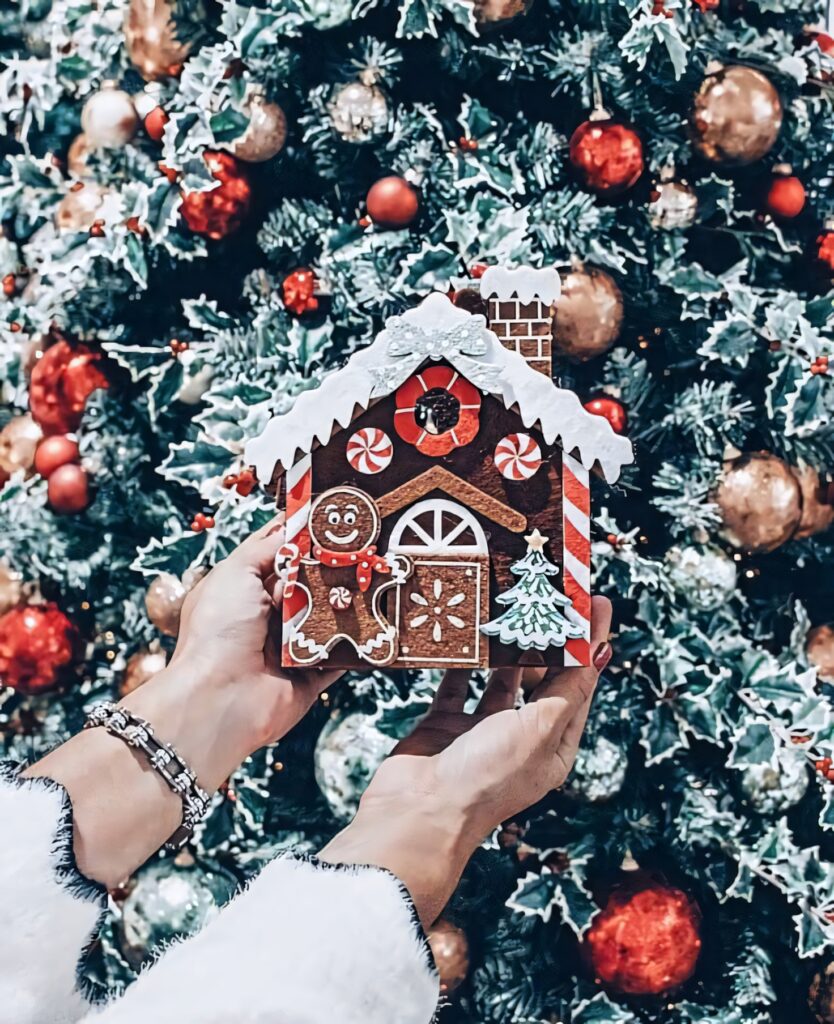 Holiday Delight: Gingerbread House Amidst Festive Christmas Tree Wallpaper