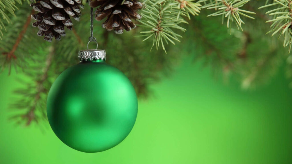 Vibrant Green Christmas Ball on Pine Tree Branch: Festive Holiday Scene Wallpaper