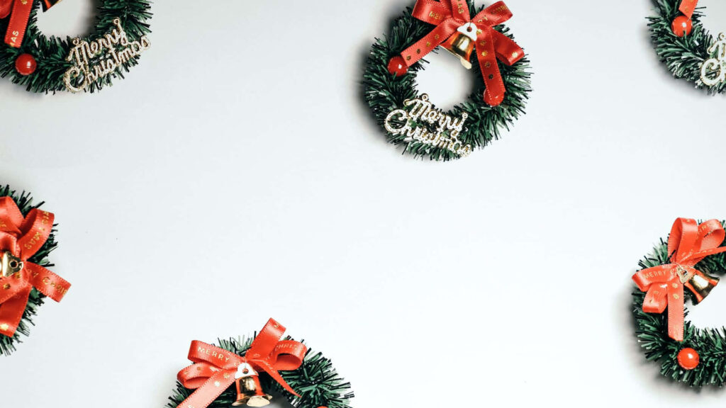 Festive Green Wreath Wallpaper with Red Ribbons & Gold Bells